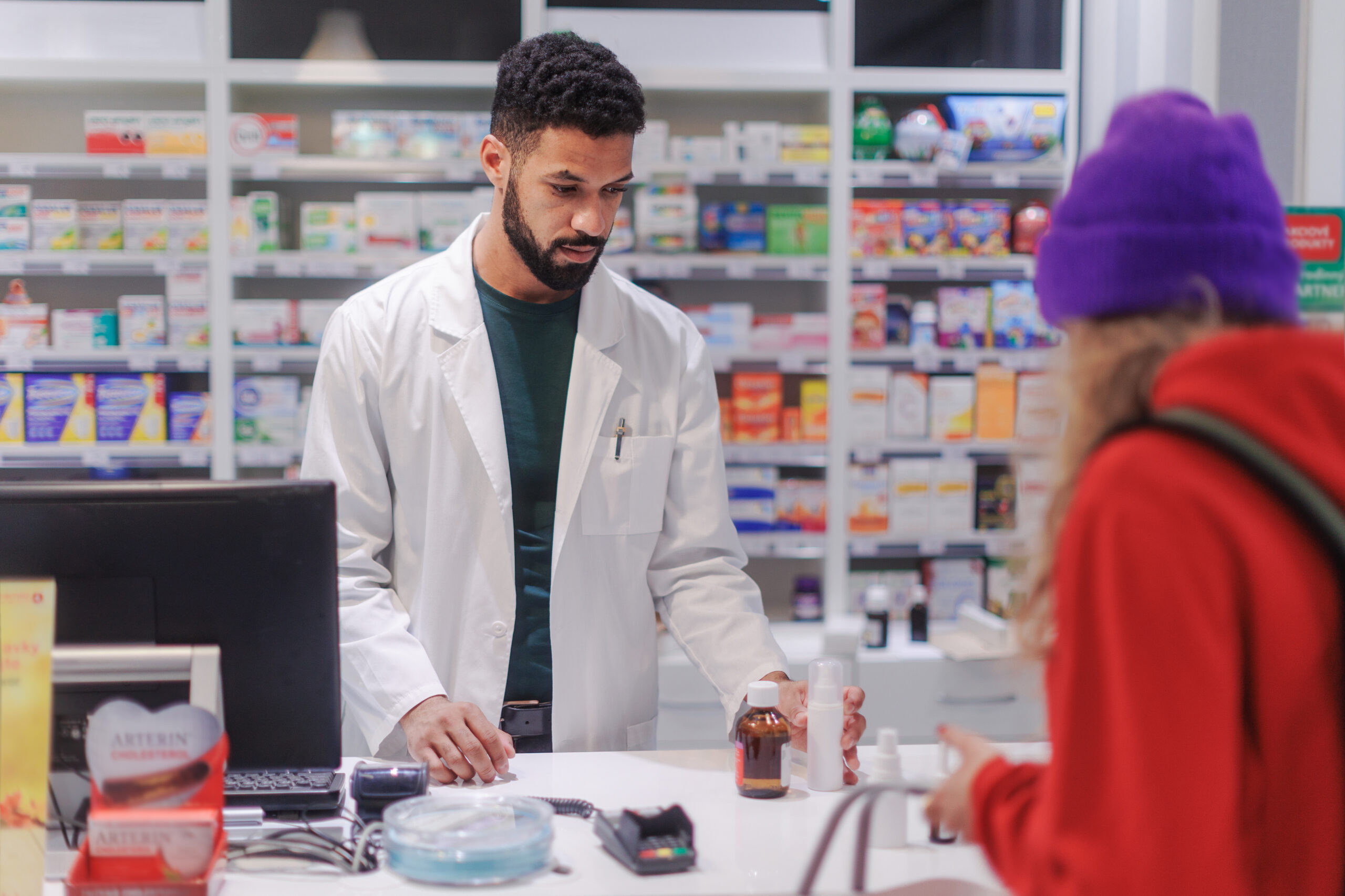 A photo of a pharmacist helping a young customer check out