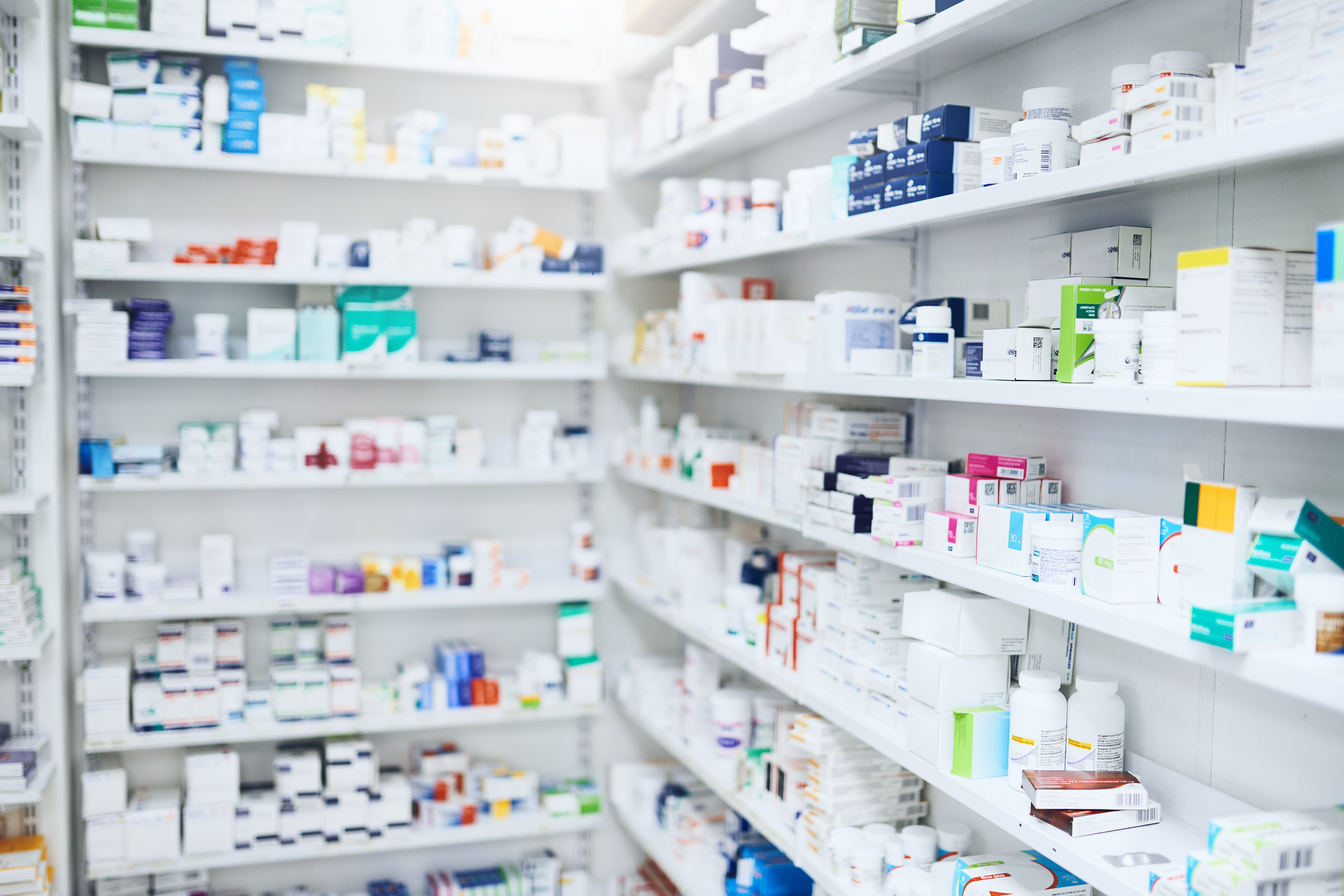 A photo of a pharmacy with stocked shelves of medication